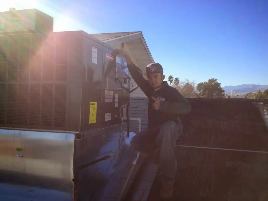 HVAC technician performing AC Tune-Up on a rooftop unit in Spanish Fort
